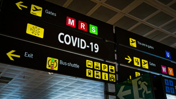 Information panel with Covid-19 word on it at an international airport.